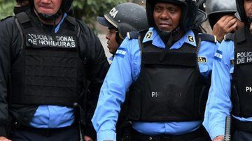 Una manifestante se acuesta frente a la policía en una protesta en Honduras.