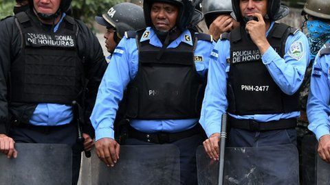 Una manifestante se acuesta frente a la policía en una protesta en Honduras.