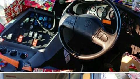 Conductor de autobús regala juguetes a los niños.