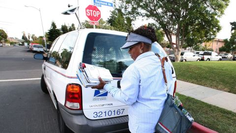 Una empleada postal entrega correo en el sur de Los Ángeles.