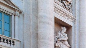 Turistas visitan la fuente y lanzan monedas pidiendo deseos.