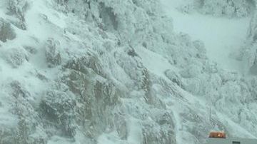 Trabajadores se encuentran despejando la nieve en la zona de las montañas de Chilao en la autopista Crest de Los Ángeles.