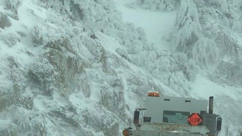Trabajadores se encuentran despejando la nieve en la zona de las montañas de Chilao en la autopista Crest de Los Ángeles.