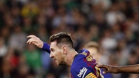 El delantero argentino del FC Barcelona, Lionel Messi deja atrás a los jugadores del Real Betis.