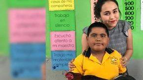 El menor posa junto a su maestra.