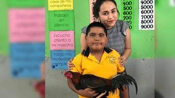 El menor posa junto a su maestra.