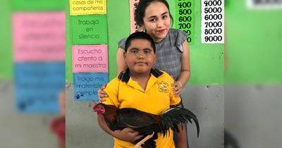 El menor posa junto a su maestra.