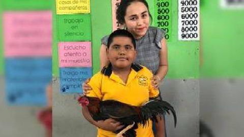 El menor posa junto a su maestra.