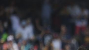 Jugadores de Pumas festejan mientras los de Chivas se lamentan en la cancha de CU.