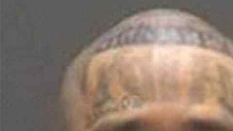 El pandillero tiene las letras "M" y "S" en sus mejillas y el número 13 en su barbilla.