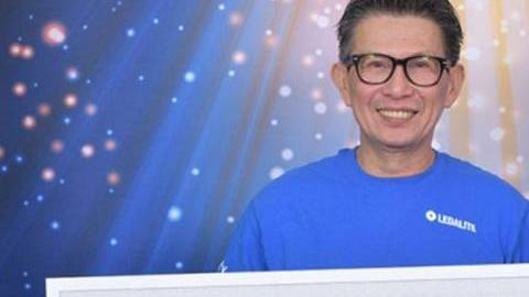 Hung Sengsouvanh posa con su cheque de $ 1 millón.