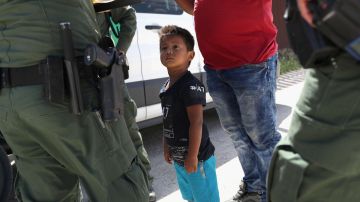 Un niño y su padre, originarios de Honduras, piden asilo a agentes fronterizos.
