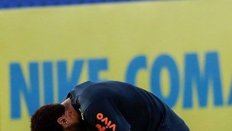 El futbolista brasileño Neymar toca su rodilla izquierda durante el entrenamiento de la selección brasileña.