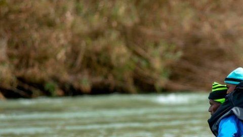 Familias de migrantes con niños cruzan cada día el Río Bravo.