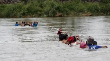 Migrantes hondureños cruzan a pie el río Suchiate, que separa a Guatemala de México.