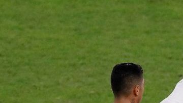 Gonzalo Jara de Chile traba a un aficionado que invadió el campo, durante el partido Chile-Uruguay de la Copa América.