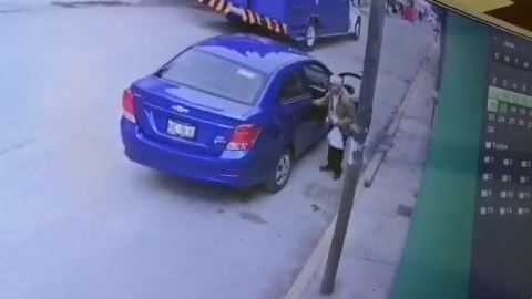 El hombre lleva una bolsa de ropa en la mano.