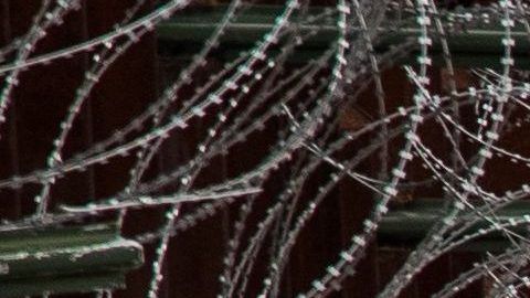 La foto muestra una alta valla reforzada con alambre de púas en Nogales. Robert Bushell/CBP