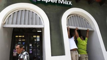 Comerciantes tapan con zinc las puertas de sus negocios en San Juan.