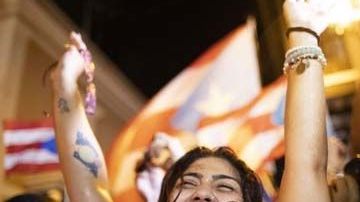 Una joven celebra la salida del gobernador de Puerto Rico, Ricardo Rosselló, en el exterior de La Fortaleza.