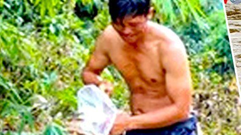 La crecida del río Nam Chim obliga a los niños a cruzar metidos en bolsas de plástico.