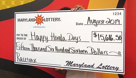 "Happy Honda Days" sostiene el cheque de su premio de lotería.