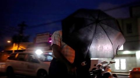 Dos ciudadanos se cubren con una sombrilla durante el paso de la tormenta Karen, en San Juan.