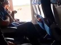 Una mujer abre la puerta de emergencia durante un vuelo.