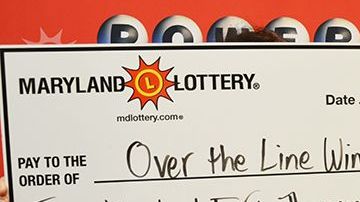 El afortunado jugador muestra su premio de Powerball.