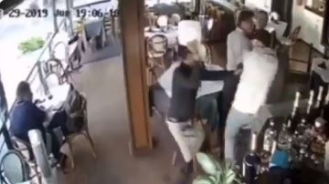 El mesero le dio el plato en la cabeza.