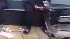 El ladrón apuntando a la victima en la silla del barbero