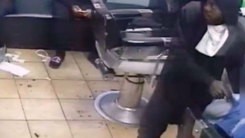 El ladrón apuntando a la victima en la silla del barbero