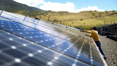 Un trabajador limpia los paneles en un parque de energía solar.