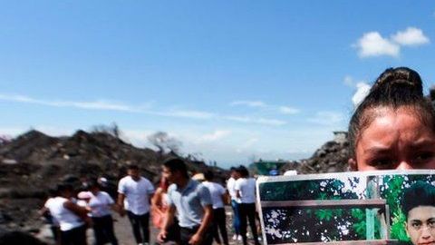 Una mujer sostiene la foto de unos familiares que murieron por la erupción del Volcán de Fuego el 3 de junio de 2018.