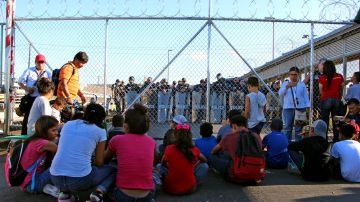 Niños migrantes bloquean un puente fronterizo en Texas.
