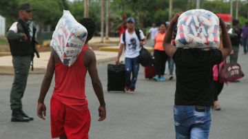 Personas con alimentos cruzan la frontera entre Colombia y Venezuela  en Paraguachón,
