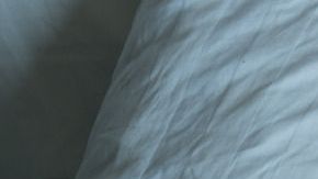 man lying in bed at home suffering from headache or hangover