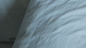 man lying in bed at home suffering from headache or hangover