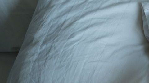 man lying in bed at home suffering from headache or hangover