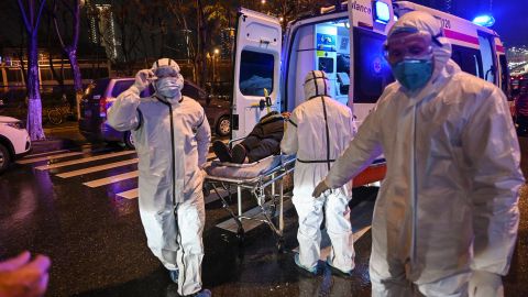 Personal sanitario conduce a un enfermo al Hospital de la Cruz Roja en Wuhan.