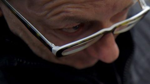 Un hombre observa atentamente un disco de vinil antes de comprarlo