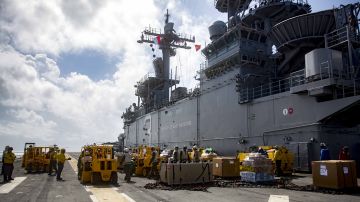 Personal de la Marina estadounidense ingresan suministros en el USS Kearsarge que se dirige a Puerto Rico.