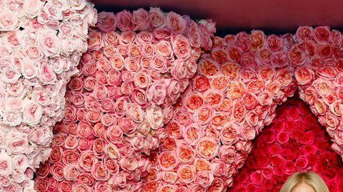 Gwyneth Paltrow enmarcada por una representación de una vulva hecha con rosas para el lanzamiento de su serie The Goop Lab.