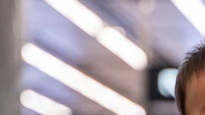 Una mujer lleva a un bebé con una máscara protectora en Hong Kong.