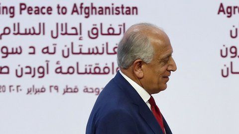 El representante especial de EEUU Zalmay Khalilzad, da la mano al cofundador del Talibán, Mullah Abdul Ghani Baradar.