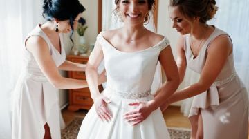 2_Bridesmaids-helping-gorgeous-bride-to-dress-up-and-get-ready-for-her-wedding-ceremony
