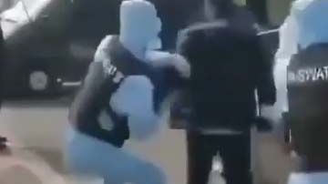 Los agentes intentan detener al supuesto portador del coronavirus lanzándole un embudo en la cabeza.