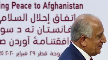 Zalmay Khalilzad da la mano al cofundador del Talibán, Mullah Abdul Ghani Baradar, durante la firma del acuerdo .