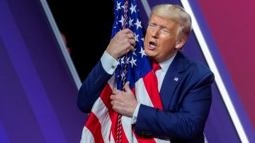 Trump abraza la bandera durante la Conferencia Anual de Acción Política Conservadora.