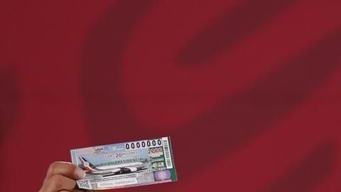 AMLO muestra su billete para la rifa del avión presiencial.
